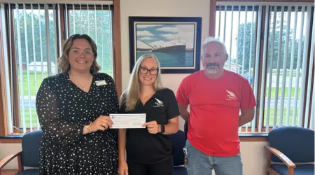 AAACU Team member presents a check to a member of the Cheboygan High School Senior Class of 2025